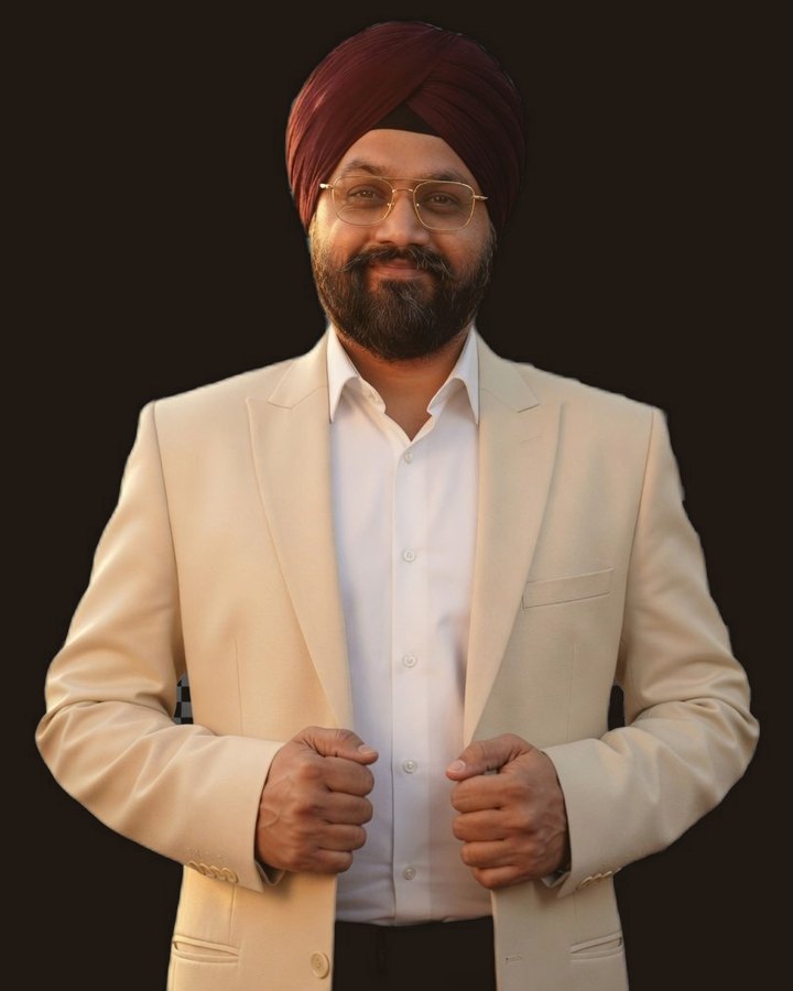 Ravinder Singh, founder of Roots & Rivers, smiling warmly in a cream blazer